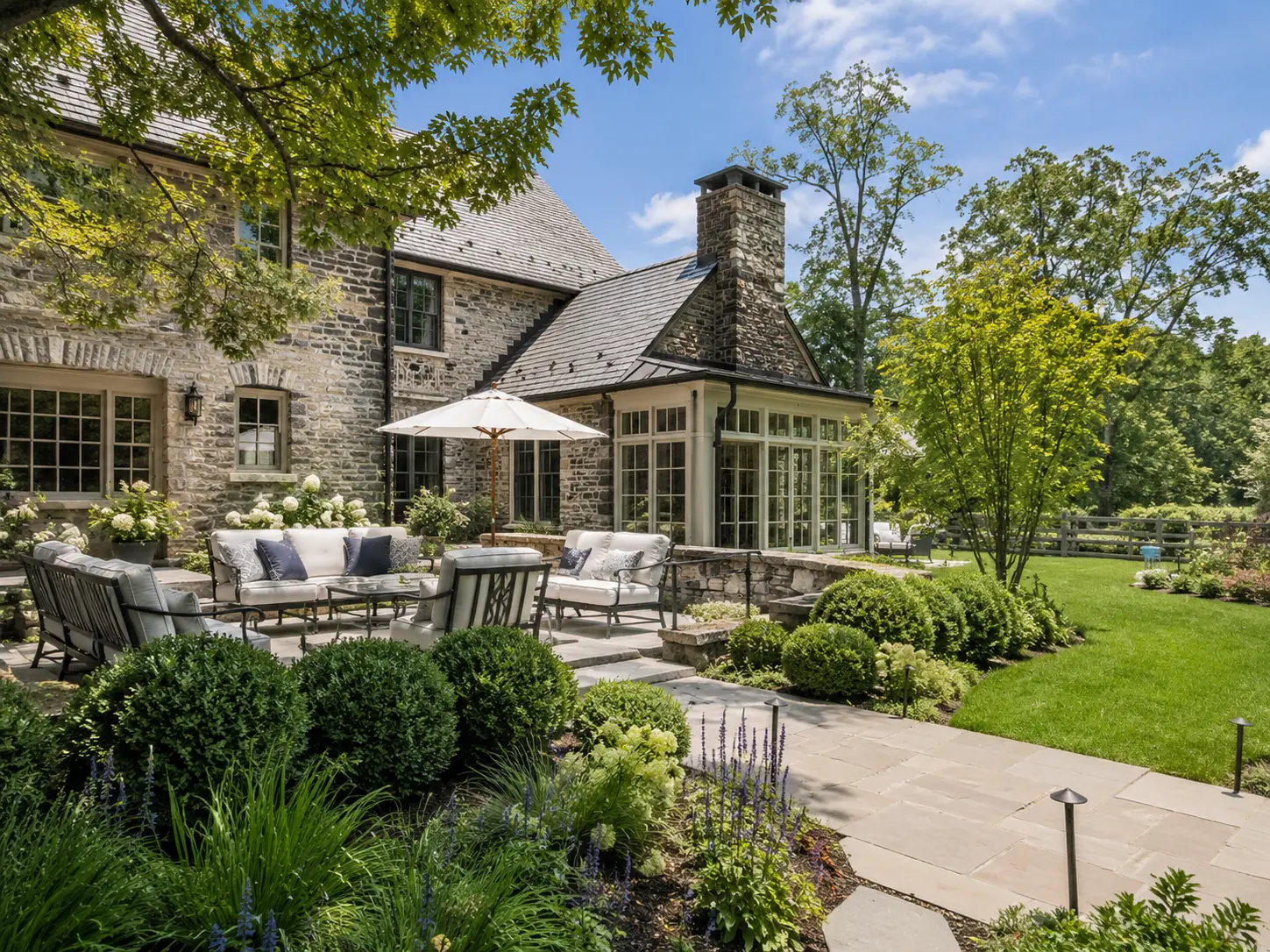 Luxury New Hope PA home with stone patio, landscaped backyard, and outdoor seating area