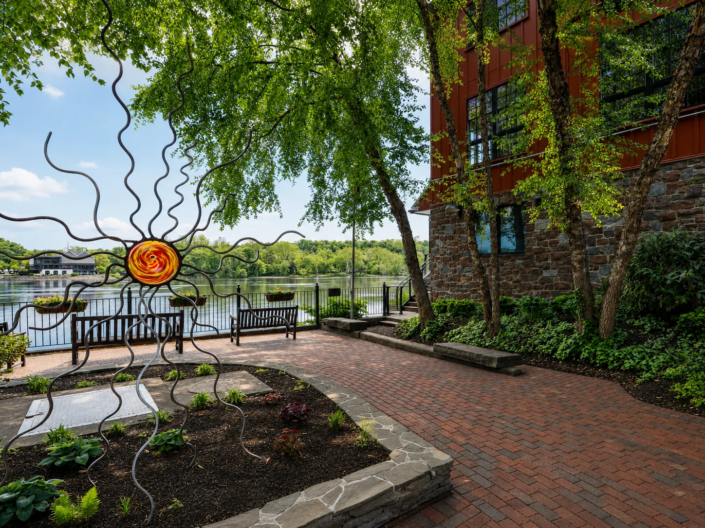 Delaware River waterfront in New Hope, PA, with public seating and art.